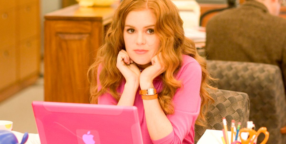 Isla Fisher as Rebecca Bloomwood leaning over a pink laptop
