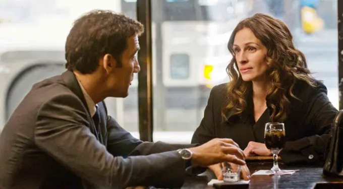 man and woman talking across bar table with drinks