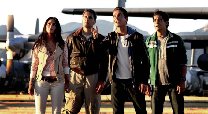 Four characters stand near military aircraft in sunset light