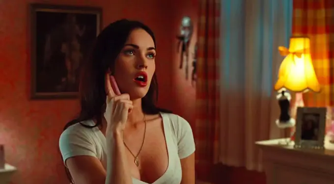 Woman in white top talking on pink phone, surprised expression