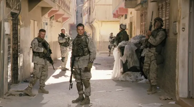 soldiers in combat gear stand alert in narrow alley street