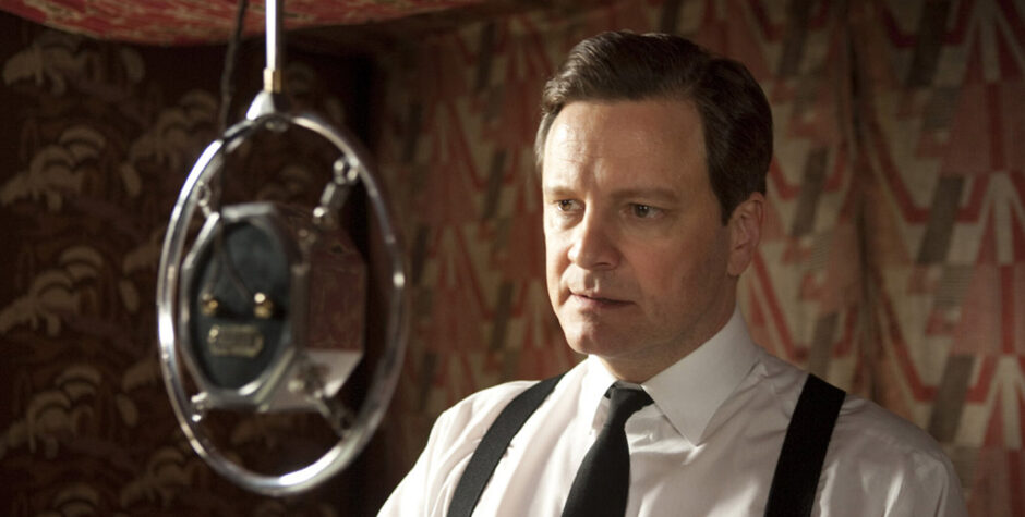 Colin Firth in period costume speaking into old-fashioned microphone