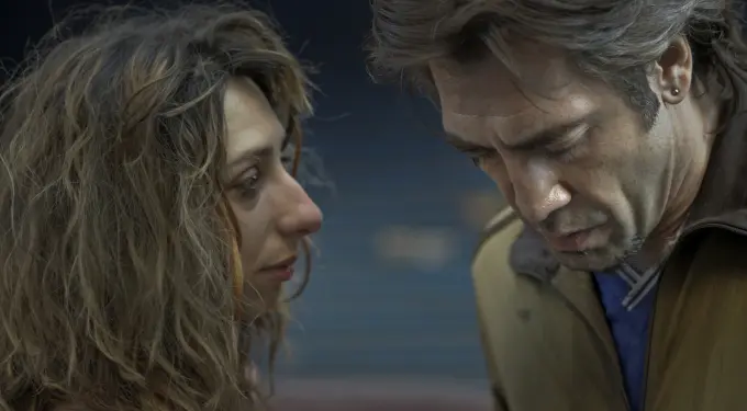 man looks down as woman watches him closely in tense scene