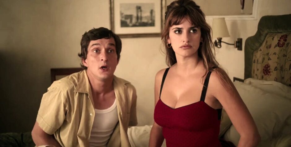 Penélope Cruz and male actor sit on bed, both looking tense