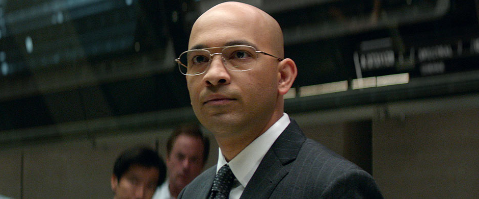 Maximiliano Hernández in suit and glasses in a Marvel movie still