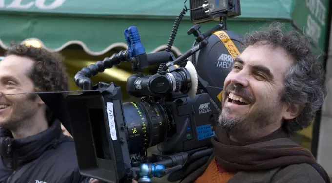 Smiling man operating ARRI film camera outdoors