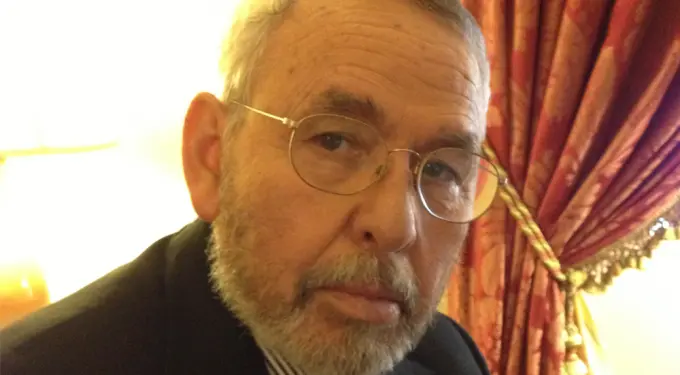 Headshot of Tony Mendez with glasses in suit indoors