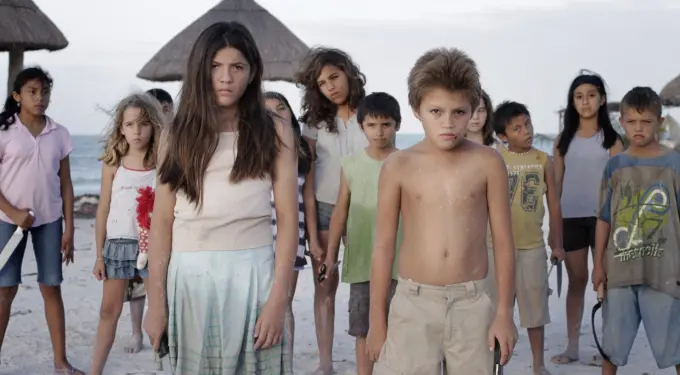 Children stand on a beach in a scene from Come Out and Play