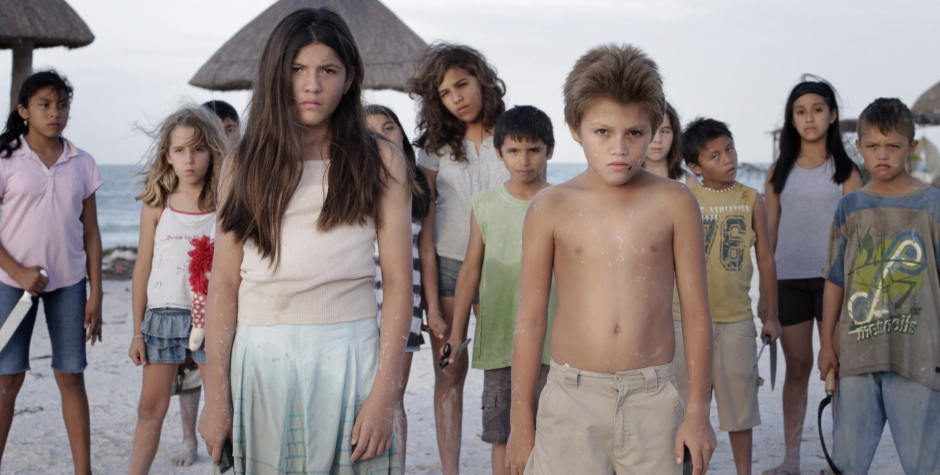 Children stand on a beach in a scene from Come Out and Play