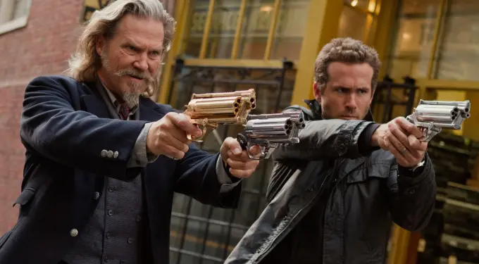 Jeff Bridges and Ryan Reynolds aim futuristic guns in a scene