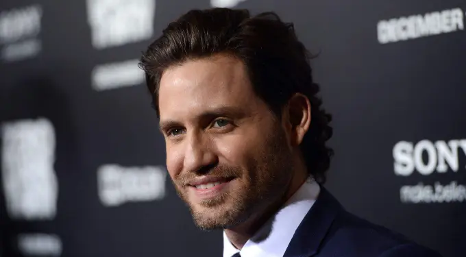 Edgar Ramirez smiling at a red carpet event in dark suit