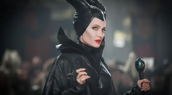Angelina Jolie in Maleficent costume holding ornamental staff