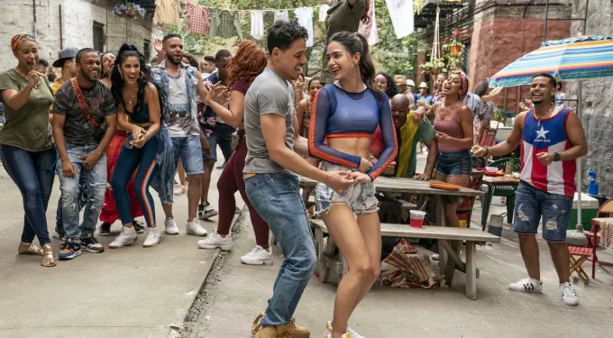 two people dance outdoors while others cheer and enjoy the party