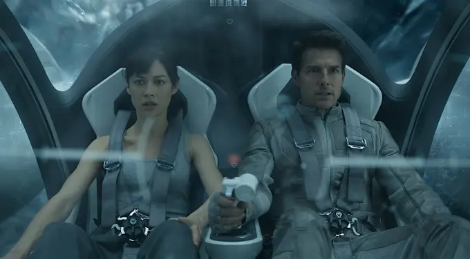 Man and woman in harnesses inside futuristic vehicle cockpit