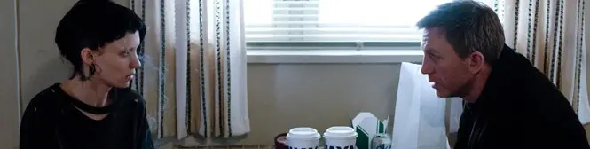 Woman and man face each other talking at table by window