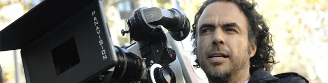man with curly hair operating Panavision film camera outdoors