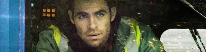 Man in green jacket looks intently out vehicle window