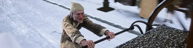 Animated man in old-fashioned clothes riding a sled in snow