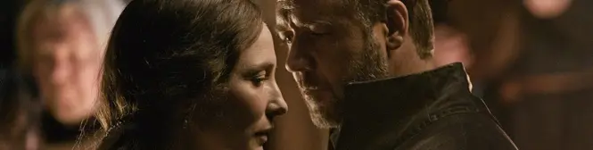 Man and woman share an intense close moment in dim light