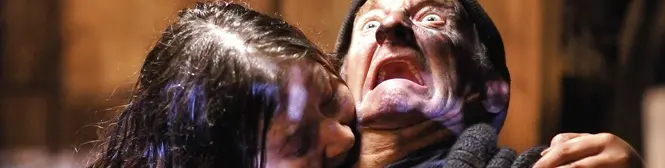 Two people in a violent struggle, one biting the other's neck