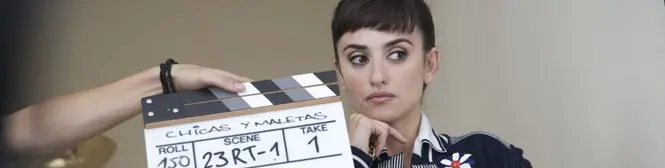 Woman seated behind clapperboard marked Chicas y Maletas scene