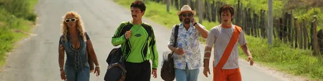 Four people walking down a country road with bags and casual clothes