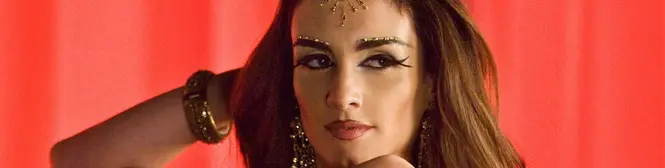 Close-up of a woman with decorative face jewelry and dark eye makeup