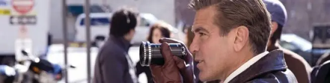 Man in leather jacket holding vintage camera outdoors