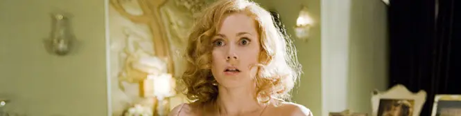 Woman with blonde curls looking surprised in vintage room