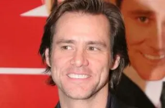 Jim Carrey headshot smiling with blurred teaser poster behind him