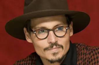 Johnny Depp close-up wearing glasses and a wide-brimmed hat