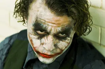 The Joker with smeared makeup looking up in intense close-up