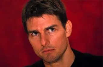 Tom Cruise close-up headshot looking serious with red background