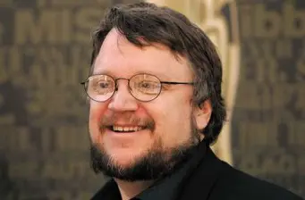 Guillermo del Toro smiling headshot with glasses and beard