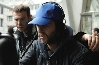 Two men working together closely behind camera equipment
