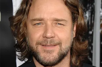 Headshot of Russell Crowe with beard and medium-length hair