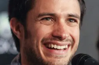 Close-up of a smiling man speaking into a microphone