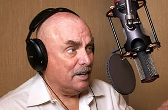 Don LaFontaine recording voiceover in studio with headphones