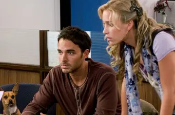 man and woman focused indoors with brown dog sitting