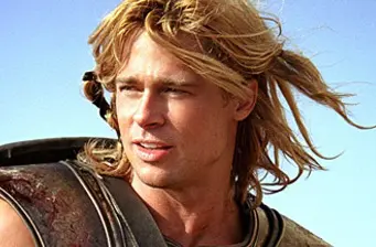Brad Pitt with long hair looks off-camera outdoors