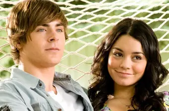 Two teens seated closely on hammock outdoors looking ahead