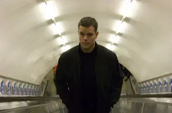 Matt Damon as Jason Bourne walking down escalator tunnel
