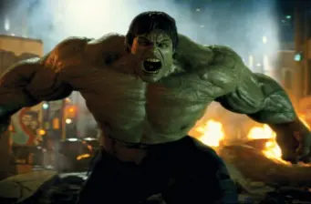 The Incredible Hulk roaring with arms flexed amid fire and smoke