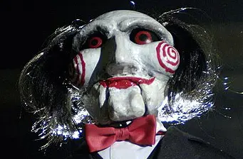 Close-up of Billy the Puppet from SAW with red bow tie