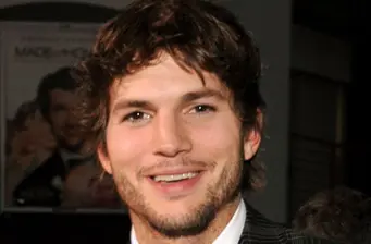 Ashton Kutcher smiling in a close-up headshot photo