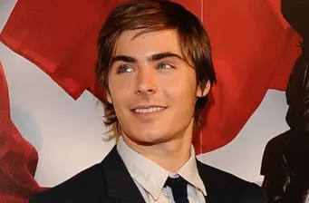 Headshot of Zac Efron in suit and tie looking off camera