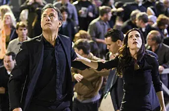 man and woman running through crowded area looking up
