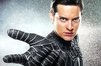 Spider-Man reaches forward wearing black symbiote suit in movie still