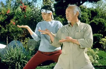 Two characters practicing martial arts stances outdoors in Karate Kid remake