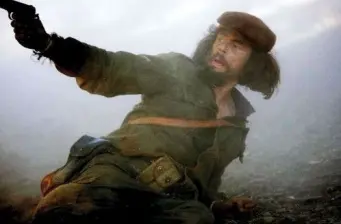 man in military outfit aiming gun in smoky scene